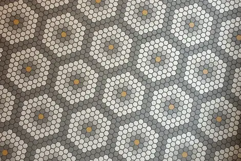 White, grey, and brown honeycomb floor tile pattern.