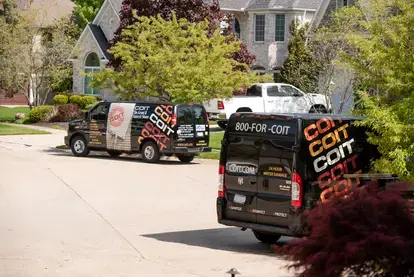 COIT vans parked in front of a house