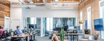People sitting at desks in an open-office environment.
