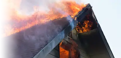 Flames engulf the roof of a home
