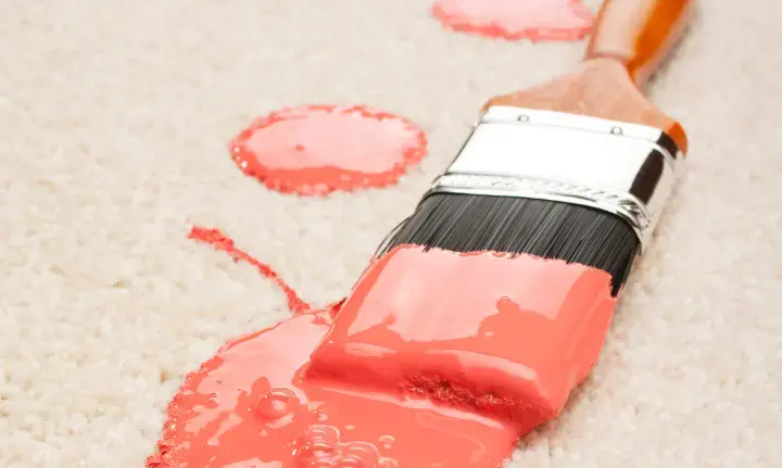 Paint brush with paint spill on carpet